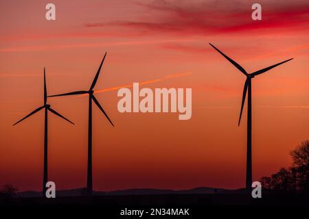 07 février 2023, Mecklembourg-Poméranie occidentale, Bützow : les rotors des éoliennes tournent après le coucher du soleil. Le gouvernement d'État de Mecklembourg-Poméranie occidentale veut stimuler l'expansion de l'énergie éolienne avec des règles uniformes pour la désignation des zones appropriées. Photo: Jens Büttner/dpa Banque D'Images