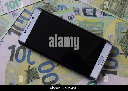 smartphone se trouve sur 100 billets en euros Banque D'Images