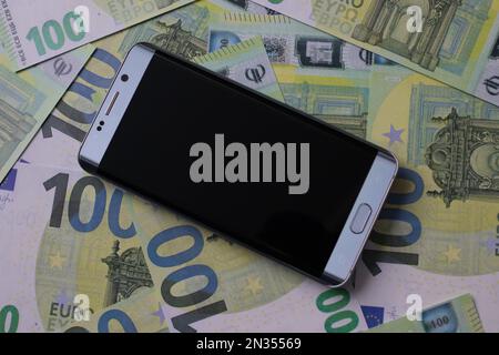 smartphone se trouve sur 100 billets en euros Banque D'Images