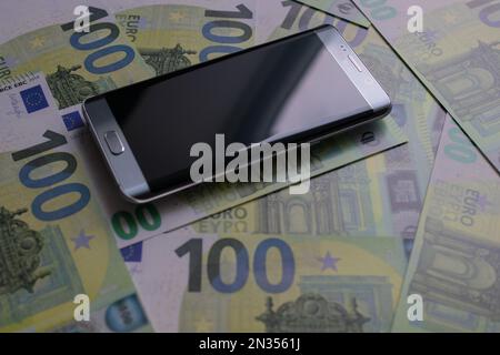 smartphone se trouve sur 100 billets en euros Banque D'Images