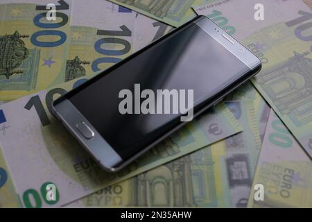 smartphone se trouve sur 100 billets en euros Banque D'Images