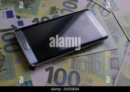 smartphone se trouve sur 100 billets en euros Banque D'Images