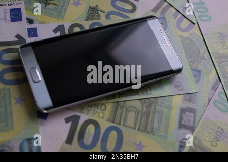 smartphone se trouve sur 100 billets en euros Banque D'Images