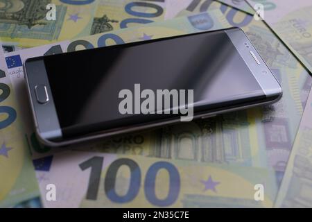 smartphone se trouve sur 100 billets en euros Banque D'Images