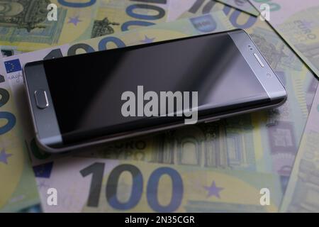 smartphone se trouve sur 100 billets en euros Banque D'Images