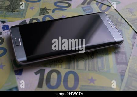 smartphone se trouve sur 100 billets en euros Banque D'Images