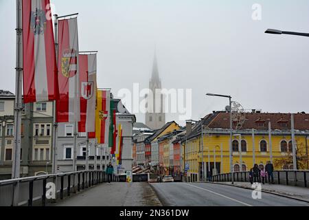 Villach, Autriche - 24 décembre 2022. Un réveillon de Noël brumeux sur le pont de Draubrucke traversant la rivière Drava dans le centre historique de Villach Banque D'Images