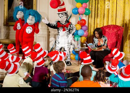 First lady Michelle Obama, with Dr. Seuss characters the Cat in the Hat, Thing 1, and Thing 2, reads to local students as part of her 'Let's Move, Let's Read!' initiative, Wednesday, Jan. 21, 2015, in the East Room of the White House in Washington. The book, Dr. Seuss’s 'Oh, The Things You Can Do That Are Good for You: All About Staying Healthy,' has been updated with the help of the Partnership for a Healthier America and includes healthy foods and exercises. (AP Photo/Jacquelyn Martin)