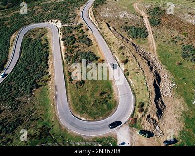 Vue aérienne de la route sinueuse. Magnifique scène matinale de la chaussée asphaltée. Autoroute à travers la forêt . Présentation du concept de déplacement. Banque D'Images