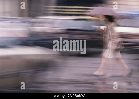 Blurred View of Woman Walking dans la pluie, Paris, France Banque D'Images