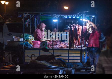 Une femme musulmane qui vend de la viande crue au principal marché de gros de légumes et de viande, Phsar Dumkor, la nuit à Phnom Penh, au Cambodge. © Kraig Lieb Banque D'Images