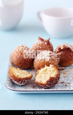 Mini beignets à gâteau avec sucre en poudre sur un plateau bleu Banque D'Images