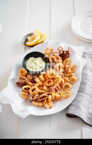 Assiette de calamars frits avec sauce tartre et citron Banque D'Images
