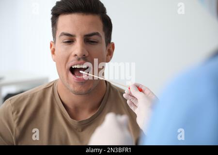 Médecin prenant l'échantillon pour le test d'ADN de l'homme en clinique Banque D'Images