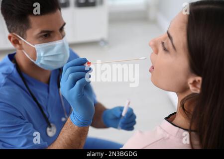 Médecin prenant l'échantillon pour le test d'ADN de la femme en clinique Banque D'Images