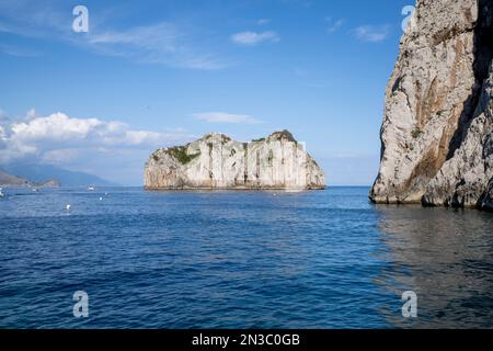 Vue sur la baie de Faraglioni et les formations rocheuses le long de la rive dans la baie de Naples au large de l'île de Capri ; Naples, Capri, Italie Banque D'Images