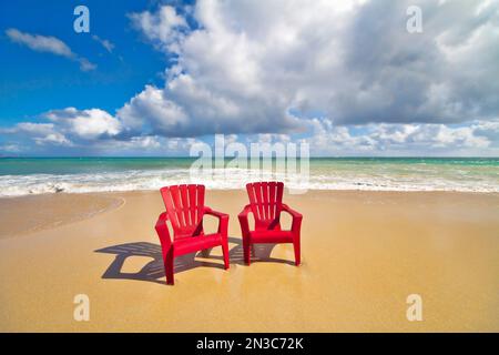Des chaises de plage rouges se dressent sur la plage de sable de Baldwin Beach sur la rive nord de Maui près de Paia ; Maui, Hawaï, États-Unis d'Amérique Banque D'Images