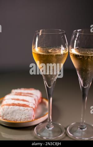 Verres de champagne au vin blanc mousseux ou cava avec bulles et dessert doux biscuits à la rose de Reims en arrière-plan, Reims, France Banque D'Images