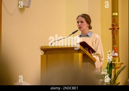 Une jeune femme lisant les Écritures pendant la Messe sur la Vigil de Pâques dans l'église Saint-Jacques à Medjugorje. Banque D'Images