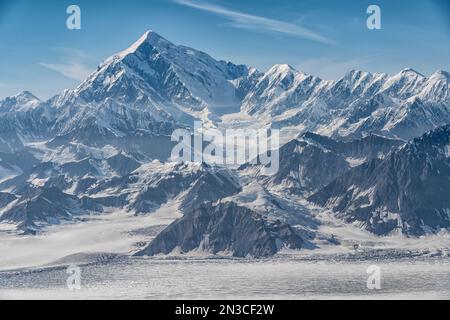 Vue aérienne du ciel bleu au-dessus du magnifique paysage du parc national de Kluane avec les sommets enneigés et les glaciers qui composent les terres... Banque D'Images