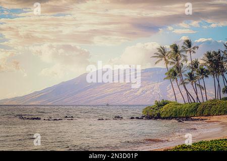 Lumière chaude sur l'océan, la plage, les palmiers et les montagnes West Maui sur l'île de Maui, Hawaii, USA ; Maui, Hawaii, États-Unis d'Amérique Banque D'Images