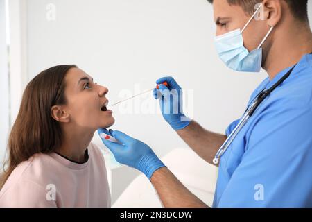 Médecin prenant l'échantillon pour le test d'ADN de la femme en clinique Banque D'Images