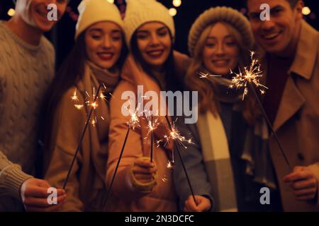 Groupe de personnes tenant des feux d'artifice, se concentrer sur les feux d'artifice Banque D'Images
