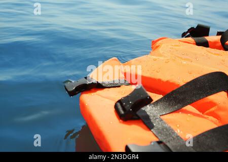 Veste orange LIFE flottante en mer, gros plan. Équipement de secours Banque D'Images