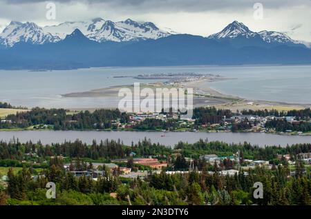 Un hydravion taxis et décolle du lac Beluga à Homer, Alaska avec une vue sur l'Homer Spit, les montagnes Kenai, et la ville d'Homer depuis une va... Banque D'Images