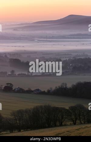 Le lever du soleil jette des tons pastel sur une inversion de brume matinale couchée sur la campagne anglaise ; Lewes, East Sussex, Angleterre, Royaume-Uni Banque D'Images