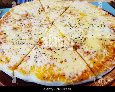 Pizza napolitaine servie sur une planche de bois Banque D'Images