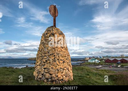 Formation de pierre avec réflecteur radar au sommet d'une colline surplombant le port de Flatey Island, faisant partie d'un amas d'une quarantaine de grandes et petites îles... Banque D'Images