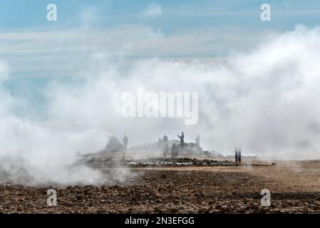 Les gens se tenant à la vue et prenant des photos du lac Myvatn, entouré par la vapeur qui s'élève des évents géothermiques. La région du lac Myvatn est... Banque D'Images