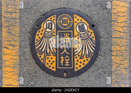 tokyo, kawagoe - déc 31 2022 : sol en asphalte avec une couverture de trou d'homme en fonte ornée d'une illustration représentant les drapeaux matoi utilisés dans Edo peri