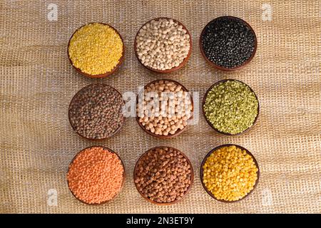 Vue de dessus de plusieurs lentilles, graines et grammes de gramme noir, lentilles rouges, masoor dal, haricots verts, pois chiches fendus, bol toor Dal Banque D'Images