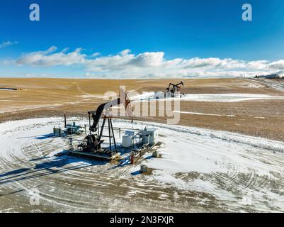 Vue aérienne des citrouilles dans un champ enneigé avec des nuages spectaculaires dans un ciel bleu avec des nuages, à l'ouest d'Airdrie; Alberta, Canada Banque D'Images