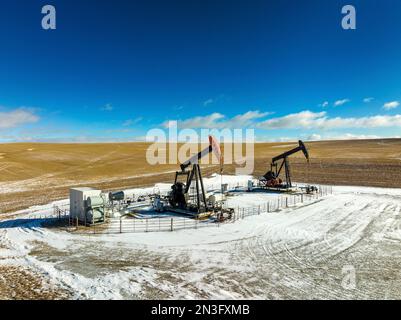 Vue aérienne des citrouilles dans un champ enneigé avec des nuages spectaculaires dans un ciel bleu avec des nuages, à l'ouest d'Airdrie; Alberta, Canada Banque D'Images