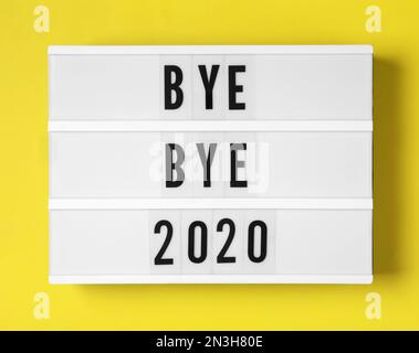 Visionneuse avec l'expression Bye Bye 2020 sur fond jaune, vue de dessus Banque D'Images