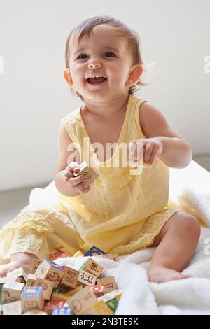 Amusez-vous avec des blocs. une adorable petite fille assise sur le sol jouant avec des jouets. Banque D'Images