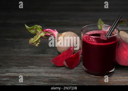 Jus de betterave frais et légumes crus sur table en bois sombre. Espace pour le texte Banque D'Images