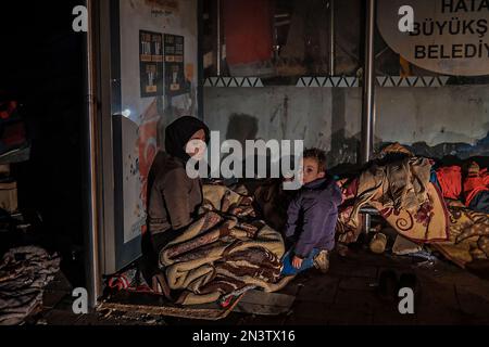 Hatay, Turquie. 24th janvier 2000. Sur le front des débris, une mère et un fils ont vu essayer de se réchauffer. La Turquie a été secouée par deux tremblements de terre majeurs centrés à Kahramanmara?. Le premier est 7,7, le second est un tremblement de terre de magnitude 7,6; il a causé une grande destruction à Kahramanmara?, Kilis, Diyarbak?r, Adana, Osmaniye, Gaziantep, ?anl?urfa, ad?yaman, Malatya et Hatay. Crédit : SOPA Images Limited/Alamy Live News Banque D'Images