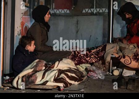 Hatay, Turquie. 24th janvier 2000. Sur le front des débris, une mère et un fils ont vu essayer de se réchauffer. La Turquie a été secouée par deux tremblements de terre majeurs centrés à Kahramanmara?. Le premier est 7,7, le second est un tremblement de terre de magnitude 7,6; il a causé une grande destruction à Kahramanmara?, Kilis, Diyarbak?r, Adana, Osmaniye, Gaziantep, ?anl?urfa, ad?yaman, Malatya et Hatay. Crédit : SOPA Images Limited/Alamy Live News Banque D'Images