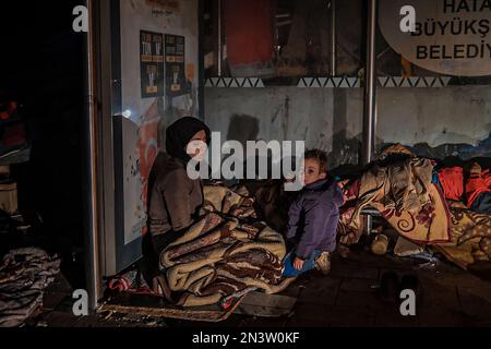 Hatay, Turquie. 24th janvier 2000. Sur le front des débris, une mère et un fils ont vu essayer de se réchauffer. La Turquie a été secouée par deux tremblements de terre majeurs centrés à Kahramanmara?. Le premier est 7,7, le second est un tremblement de terre de magnitude 7,6; il a causé une grande destruction à Kahramanmara?, Kilis, Diyarbak?r, Adana, Osmaniye, Gaziantep, ?anl?urfa, ad?yaman, Malatya et Hatay. (Photo de Murat Kocabas/SOPA Images/Sipa USA) crédit: SIPA USA/Alay Live News Banque D'Images