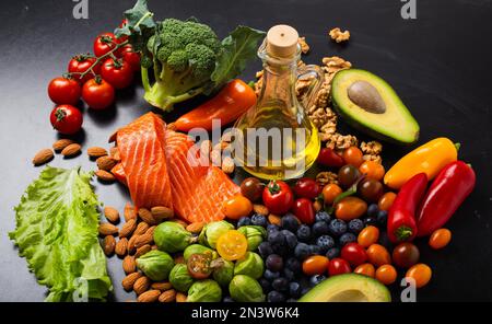 Alimentation saine et alimentation riche en vitamines et concept oméga-3, assortiment de légumes frais, salade verte, fruits, saumon de poisson, noix, bleuets Banque D'Images