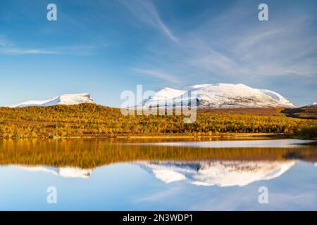 Le groupe de montagne enneigé de Lapporten se reflète dans le lac Vuolio Njahkajavri, paysage d'automne, parc national Abisko, Laponie, Suède Banque D'Images