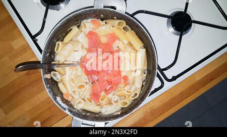 pâtes avec saumon cuisant dans une grande casserole dans la cuisine Banque D'Images