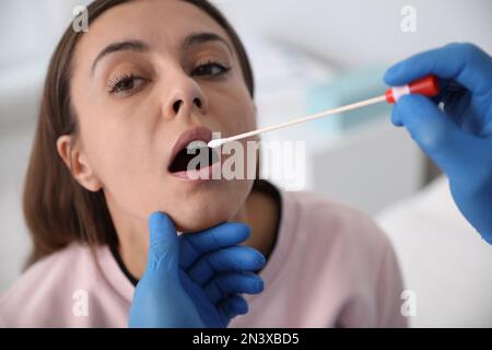 Médecin prenant l'échantillon pour le test d'ADN de la femme en clinique Banque D'Images