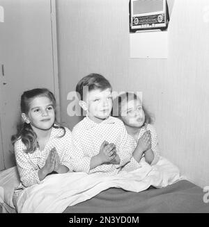 Dans le 1950s. Trois enfants au lit au coucher prononçant leurs prières du soir ensemble. Suède 1959. Kristoffersson réf. CL23-9 Banque D'Images