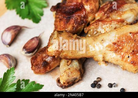 Cuisses de poulet rôties aux épices et aux herbes sur fond clair . Poulet frit au persil, à l'ail et au poivre, à côté des épices et des légumes. Banque D'Images