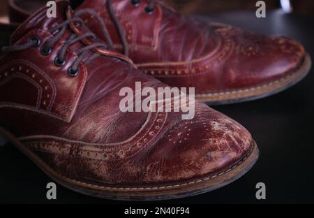 Gros plan porté vieux cuir brun rouge rayures et éraflures sur les hommes chaussures oxford Banque D'Images